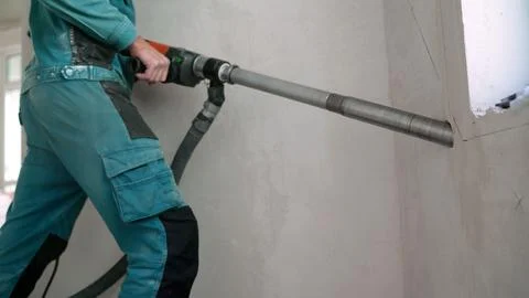 Construction worker using industrial core drill to make hole in concrete wall Stock Photos