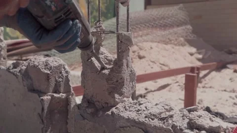 Construction worker using a jackhammer to demolish a concrete pillar Stock Footage 345335123