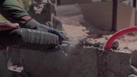 Construction worker using jackhammer to demolish concrete wall Stock Footage 345335463