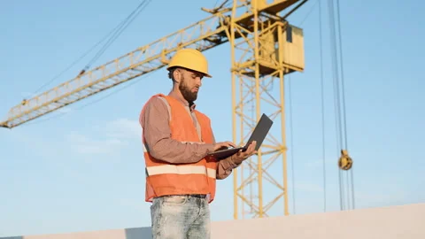 Construction worker using laptop on site to manage tasks Stock Footage 311306683