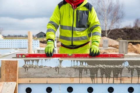 Construction Worker Using Level on Insulated Concrete Forms at Building Site Stock Photos