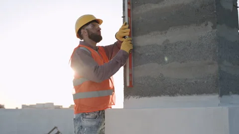 Construction worker using a level tool to ensure wall Stock Footage 286047293