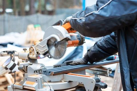 Construction Worker Using Miter Saw at Active Building Site Stock Photos