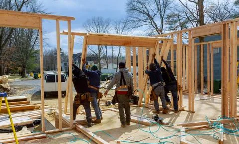 Construction Worker Using nail gun On wood building frame against Fotos de archivo