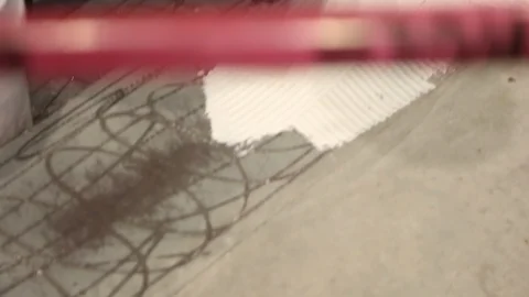 Construction worker using notched trowel to lay mortor for floor A Video stock 114924918