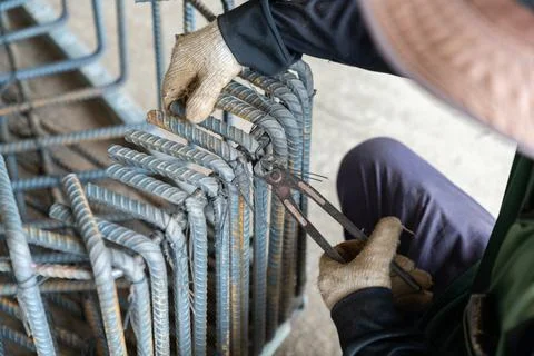 Construction worker using pincer pliers to tie steel rebar with wire for re.. Stock Photos