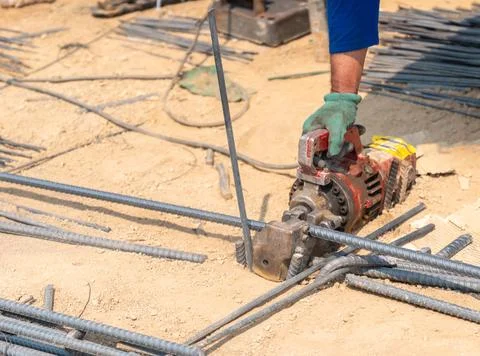 Construction worker using a portable hydraulic rebar cutter to slice throug.. Fotos de archivo