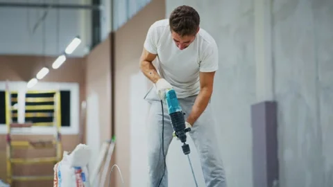 Construction Worker Using Power Drill to Prepare Walls for Renovation, Focusing Stock Footage 316063622