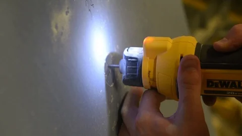 Construction worker using power tool to cut hole in sheet of plasterboard 動画素材 113394574