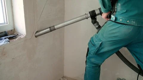 Construction worker using a professional core drill to make a hole in a concrete Stock Photos