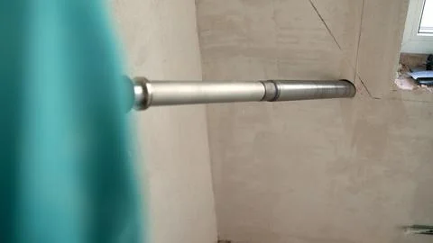 Construction worker using a professional core drill to make a hole in a concrete Stock Photos