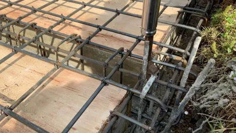 Construction worker using rebar tying tool to secure steel reinforcement bars Видео 334533635