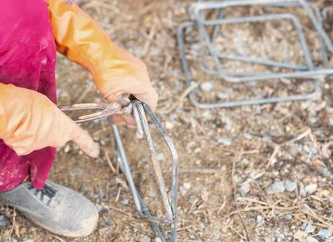 Construction worker using rebar wire to fasten together. Stock Photos
