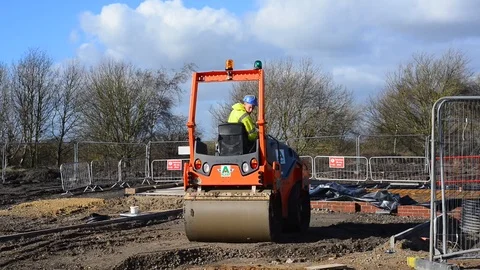 Construction worker using roller on building site of new homes selby uk Stock Footage 85928857