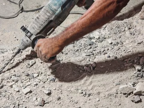 Construction Worker Using Rotary Hammer Drill on Concrete Surface Stock Photos