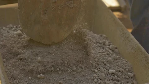 Construction worker using shovel to fill up pushcart Stock Footage 255684350