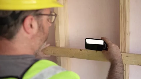 Construction Worker Using a Smartphone App as a Level Closeup Stock Footage 242620519