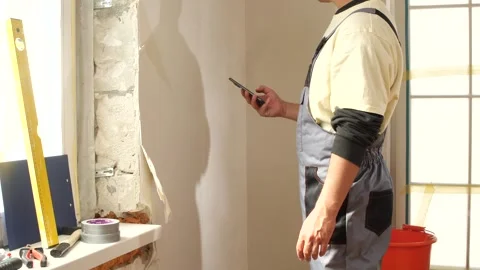 Construction worker using smartphone during renovation work Stock Footage 312671455