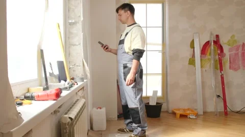 Construction worker using smartphone during apartment renovation Stock Footage 312700289