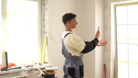 Construction worker using smartphone during home renovation project Stock Footage 314183984