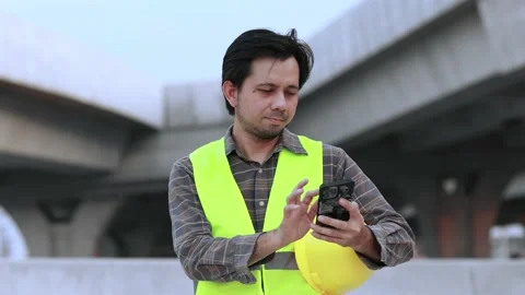 Construction worker using smartphone Stock Footage 220006076