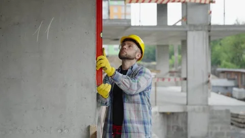 Construction worker using spirit level to check concrete wall 스톡 동영상 337466562