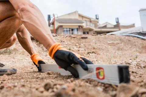 Construction worker using spirit level on site on the ground during work, close 库存照片