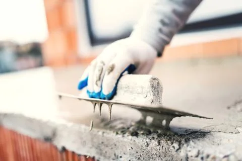 Construction worker using steel trowel for plastering Stock Photos