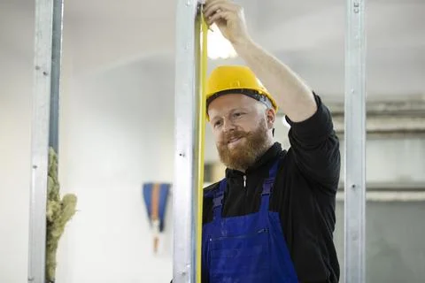 Construction worker using tape measure Фото