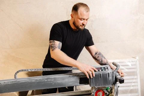 Construction worker using tile saw cutting machine preparing ceramic tiles .. Stock Photos