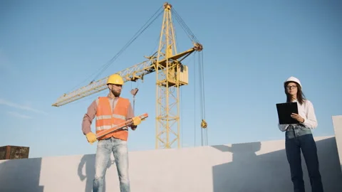 Construction worker using tools and reviewing plans on site Stock Footage 295957787