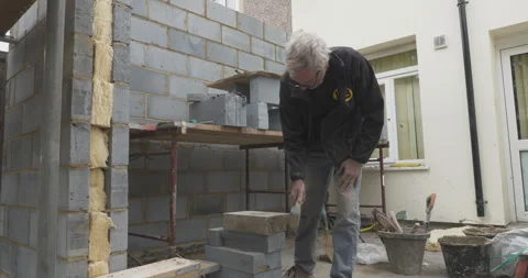 Construction worker using tools while working on a building site Stock Footage 246380783