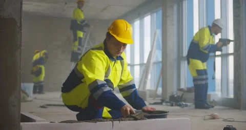 Construction worker using trowel and tools for building wall with bricks and Stock Footage 153410852