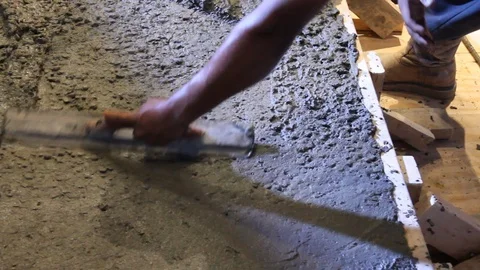 Construction worker using trowel to smooth out newly laid concrete Stock Footage 114925027