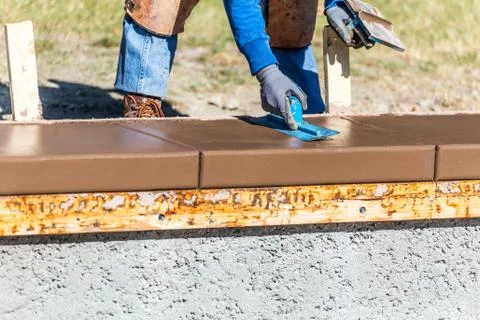Construction Worker Using Trowel On Wet Cement Forming Coping Around New Pool Stock Photos