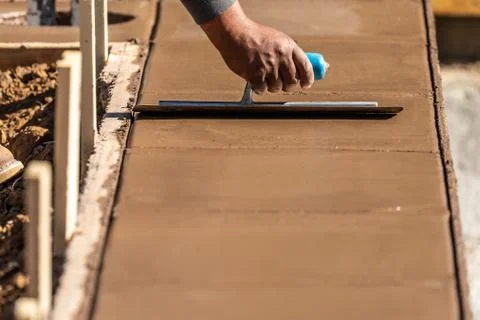 Construction Worker Using Trowel On Wet Cement Forming Coping Around New Pool Stock Photos