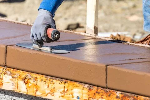 Construction Worker Using Trowel On Wet Cement Forming Coping Around New Pool Stock Photos