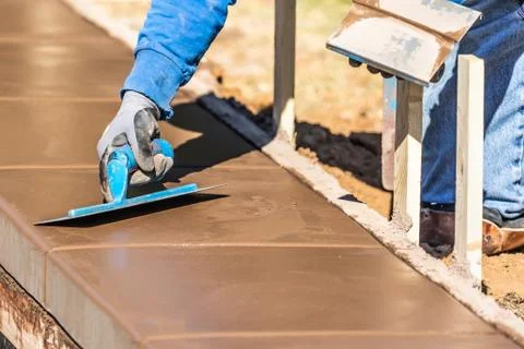 Construction Worker Using Trowel On Wet Cement Forming Coping Around New Pool Stock Photos