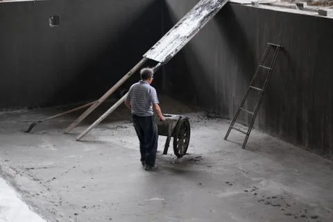Construction Worker Using Wheelbarrow Inside Empty Pool Stock Photos