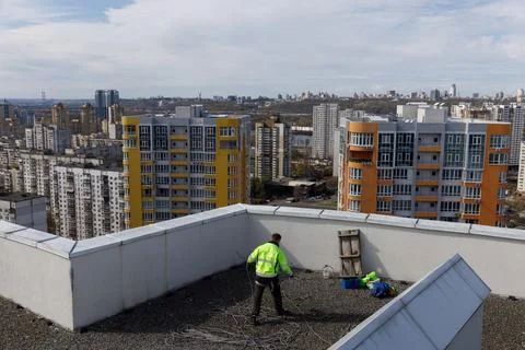 A Construction Worker Utilizing Safety Gear on a Rooftop with a Stunning Urban Stock Photos