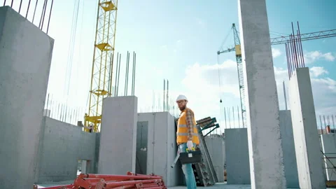 Construction worker walking and working on a construction site with a toolbox Stock-Footage 247771508