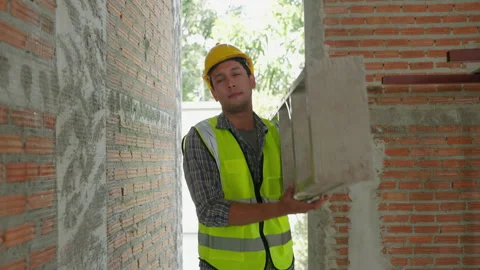 Construction worker is walking carrying a ladder inside the work site Stock Footage 231001130
