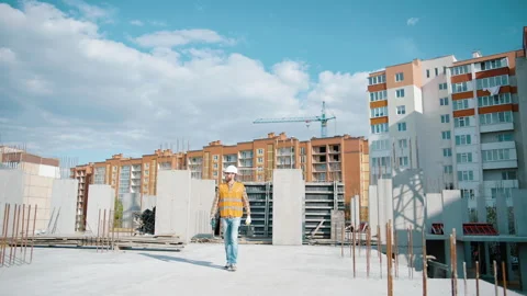 Construction worker walking on a construction site with a toolbox Video stock 253591565