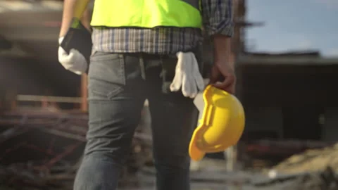 Construction worker walking with helmet off construction site Stock Footage 231001231