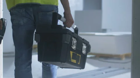 Construction Worker Walking inside Building Under Construction and Carrying Tool Stockbeeldmateriaal 67547077