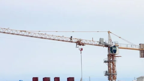 Construction worker walking on the jib of a yellow tower crane Stock Footage 341087223