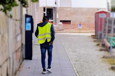 A construction worker walking on a sidewalk 스톡 사진