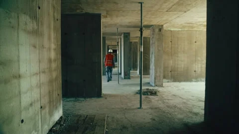 A construction worker walks inside an unfinished reinforced concrete building Stock Footage 273147475