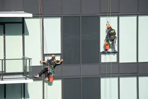 Construction worker washes windows one of the residential buildings Stock-Fotos