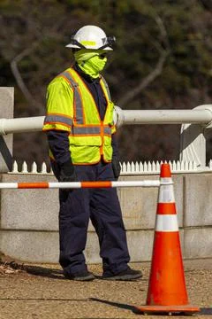 A construction worker wearing full protective gear including helmet, reflecti Stock Photos